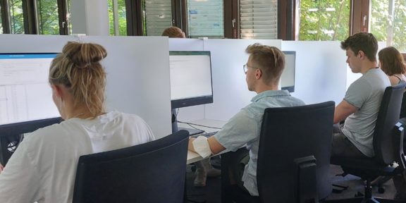 Foto: Mehrere Studierende im E-Prüfungsraum vor den PC-Bildschirmen während einer digitalen Prüfung